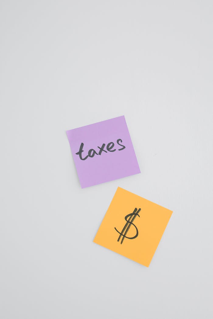 Close-up of sticky notes with tax and dollar symbols, concept for finance and organization.